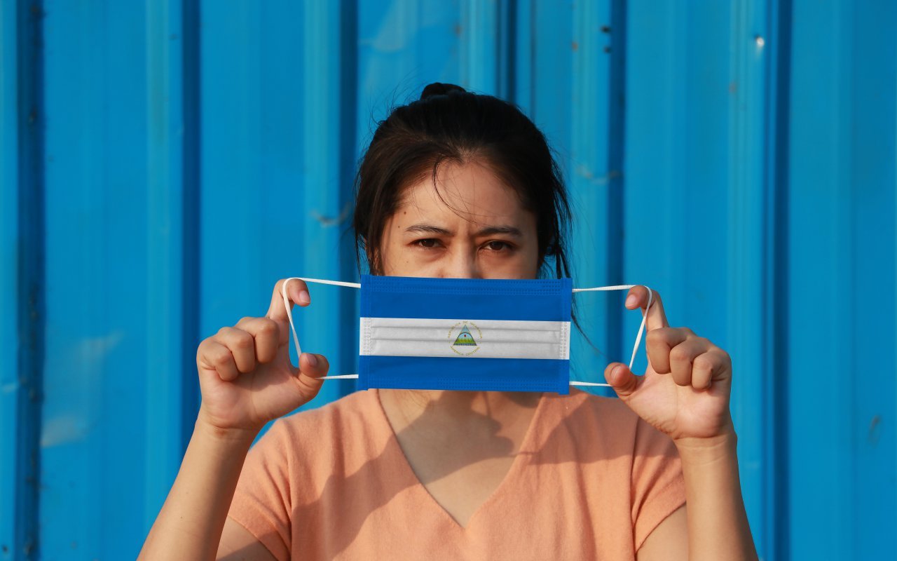 femme avec un masque drapeau nicaragua - covid 19 nicaragua protocole de voyage